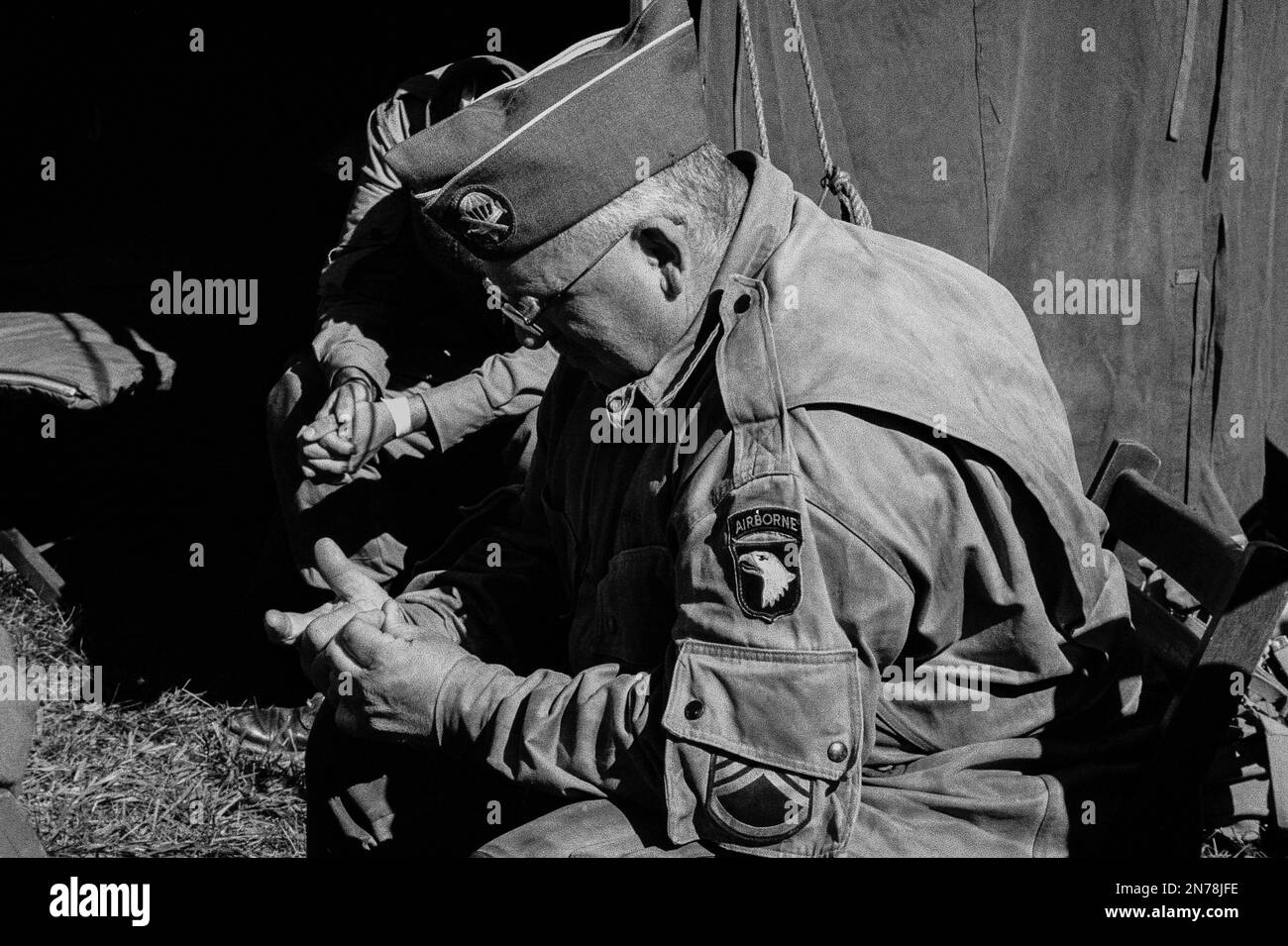 WWII soldiers who looking they are praying under a tent during a reenactment at the American Heritage Museum. The image was captured on analog black a Stock Photo