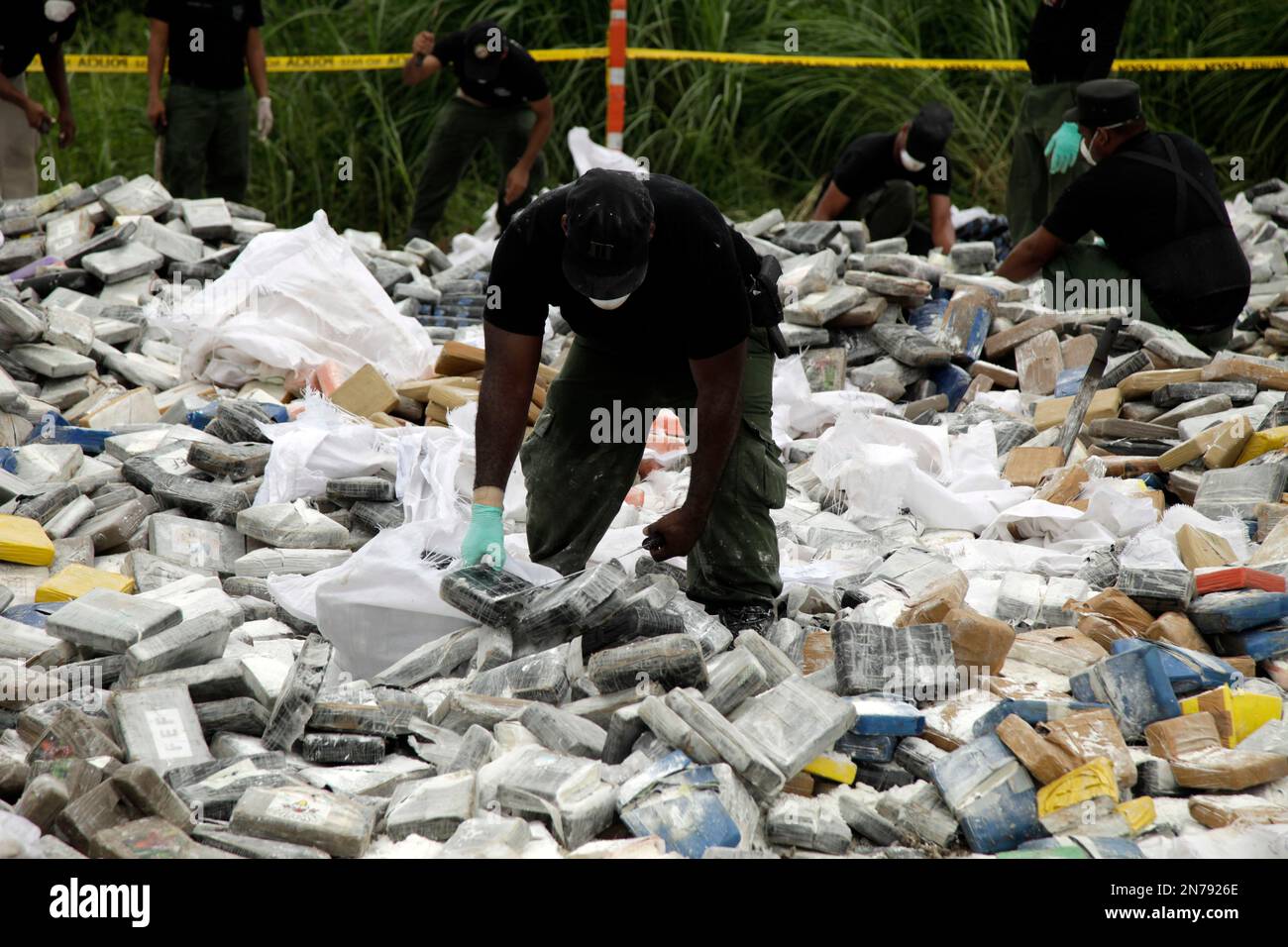 Antinarcotics police chop up packages of drugs to ready for burning in