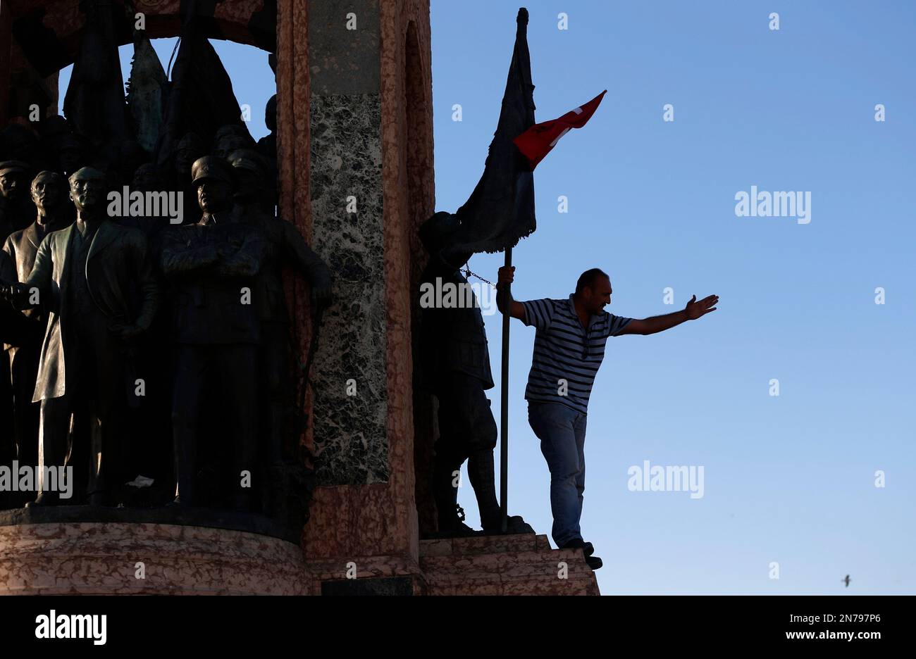 A man shouts slogans after he chained himself to the monument of ...
