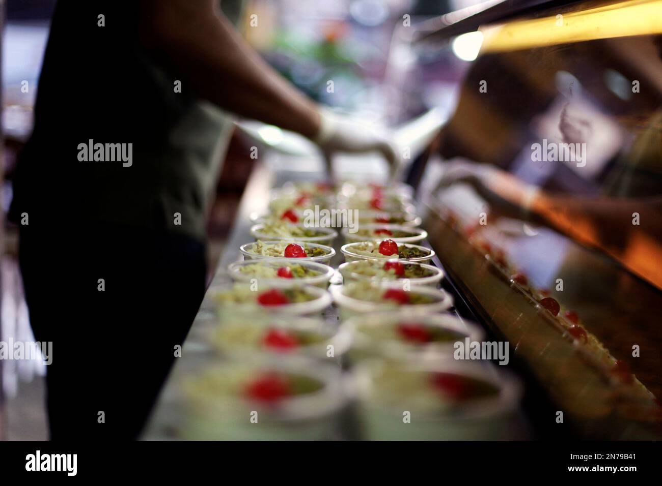 A Syrian refugee worker, organizes ice cream cups, at the Bakdash ice