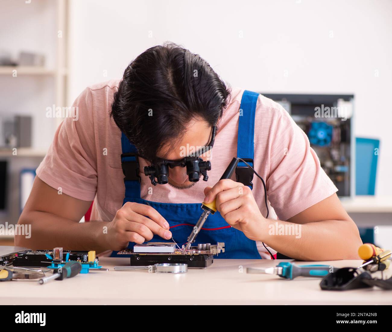 Young male contractor repairing computer Stock Photo