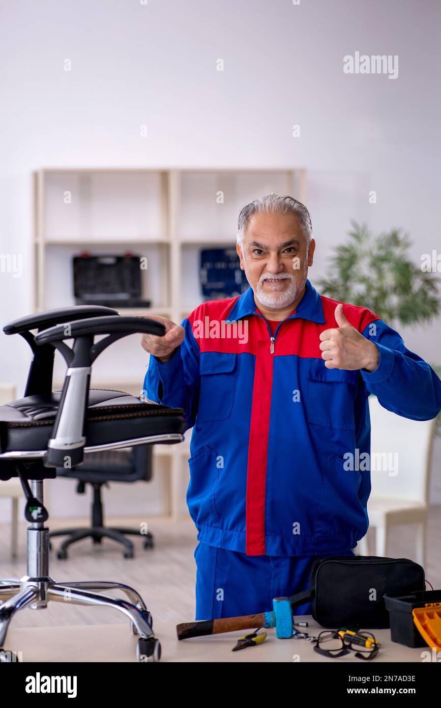 Old repairman repairing office chair Stock Photo Alamy