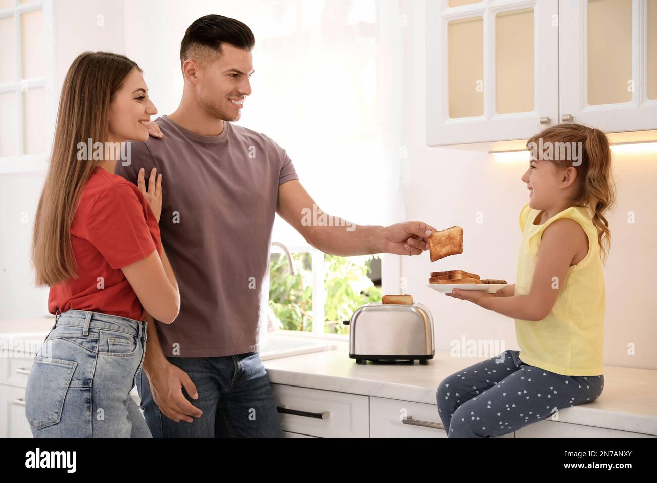 Happy family using modern toaster in kitchen Stock Photo - Alamy