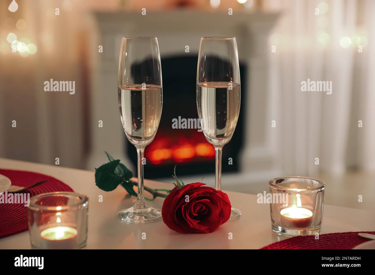 Romantic table setting with champagne, rose and candles for Valentine's ...