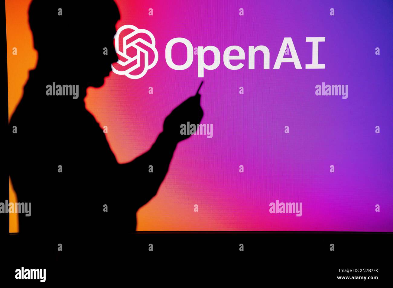 UK, LONDON. JANUARY 30, 2023: Open AI and the Advancements in Technology: Silhouette of Man Holding Smartphone Stock Photo