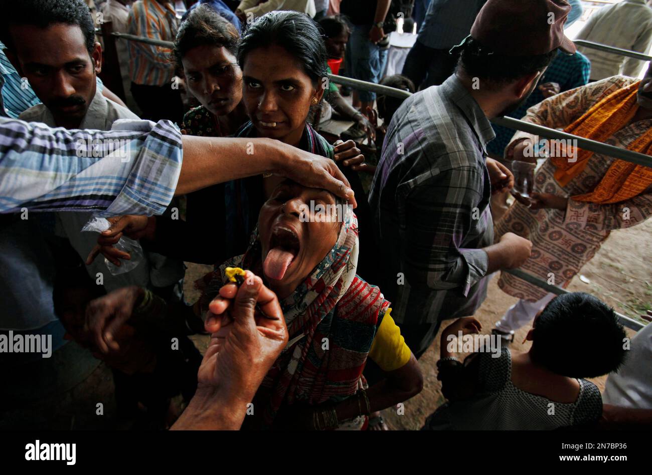 A member of the Goud family administers “fish medicine” to an asthma