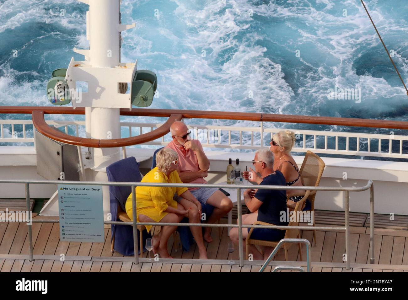 Two couples enjoy a drink on their first full sea day bound for the Mediterranean aboard the cruise ship Aurora, August 2022. Stock Photo
