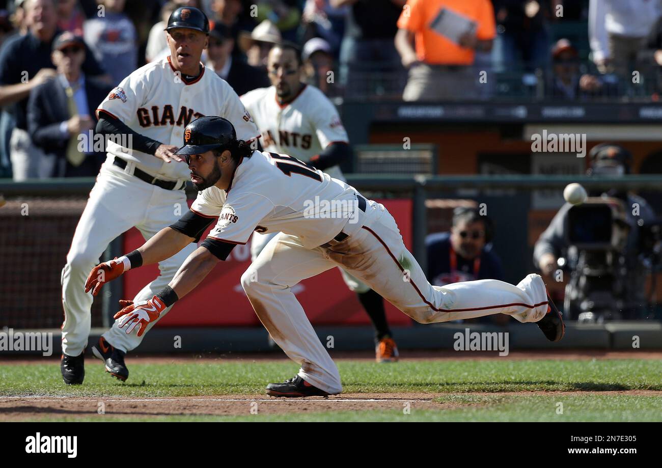 San Francisco Giants Angel Pagan slides into home to score on a two run inside the park home run during the tenth inning of a baseball game against the Colorado Rockies in San