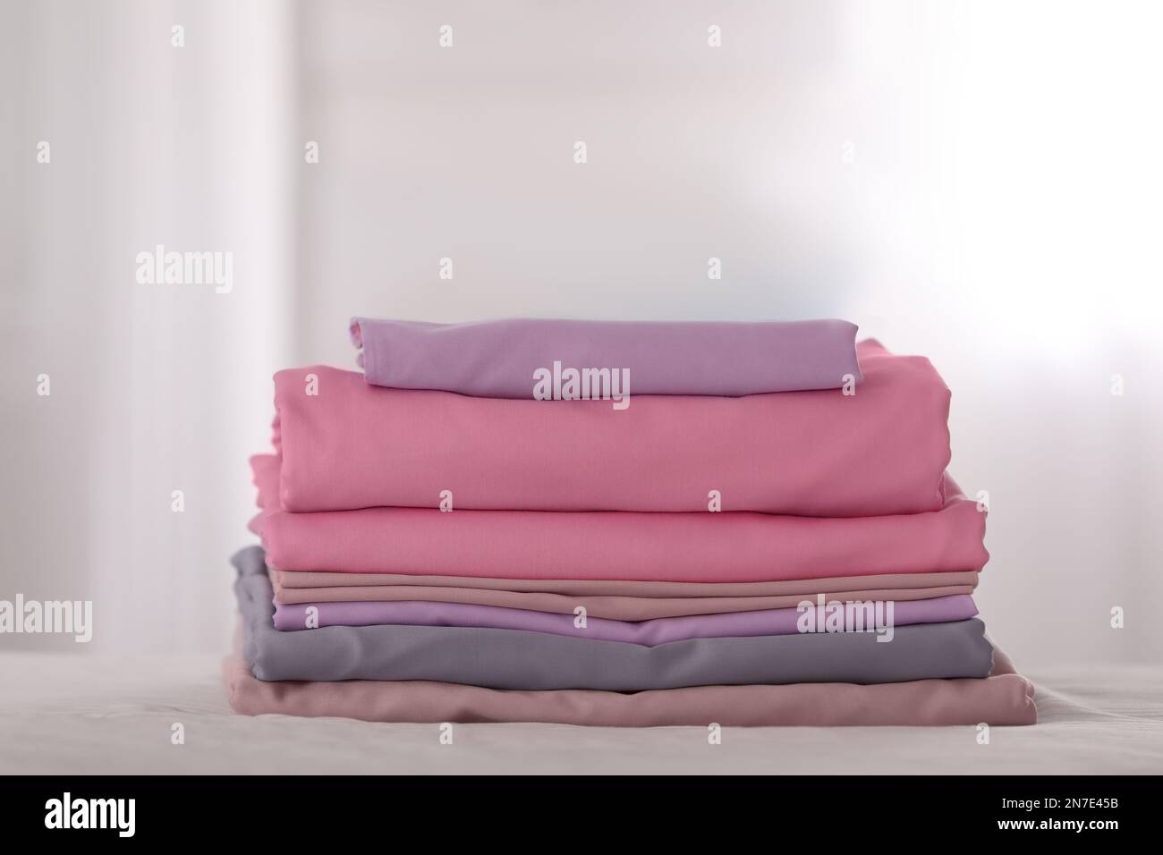 Stack of clean color folded linens on bed Stock Photo - Alamy