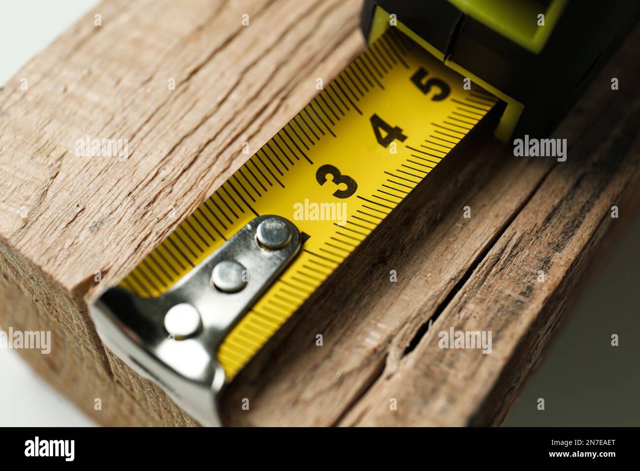 Tape measure on timber strip, closeup. Construction tool Stock Photo ...