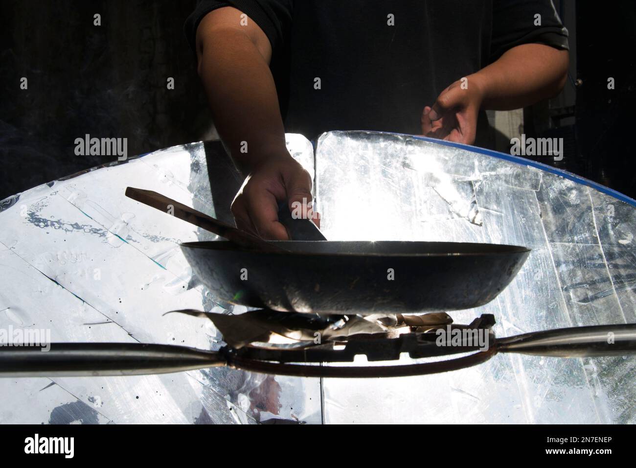 Ibrahim Rasyid, a student at the ITB School of Management Business is conducting showing a cooking using a stove that utilizes solar energy at his workshop in Bandung, West Java, Indonesia on 10 February 2023. Ibrahim Rasyid, is innovating to make a solar-powered stove. a stove that can produce heat energy by utilizing the reflection of sunlight. Mag Fire, thus the name of this solar stove, is made from recycled iron, aluminum foil and parabolic waste, making it more environmentally friendly and affordable by up to 50 percent of conventional stoves. (Photo by Dimas Rachmatsyah/INA Photo Agenc Stock Photo