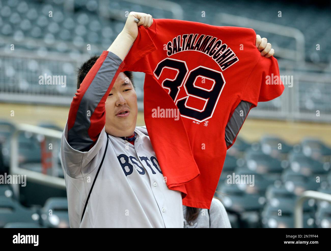 A Boston Red Sox fan waves a Jarrod Saltalamacchia jersey before the start  of a baseball game with the Minnesota Twins, Friday, May 17, 2013, in  Minneapolis. (AP Photo/Jim Mone Stock Photo 