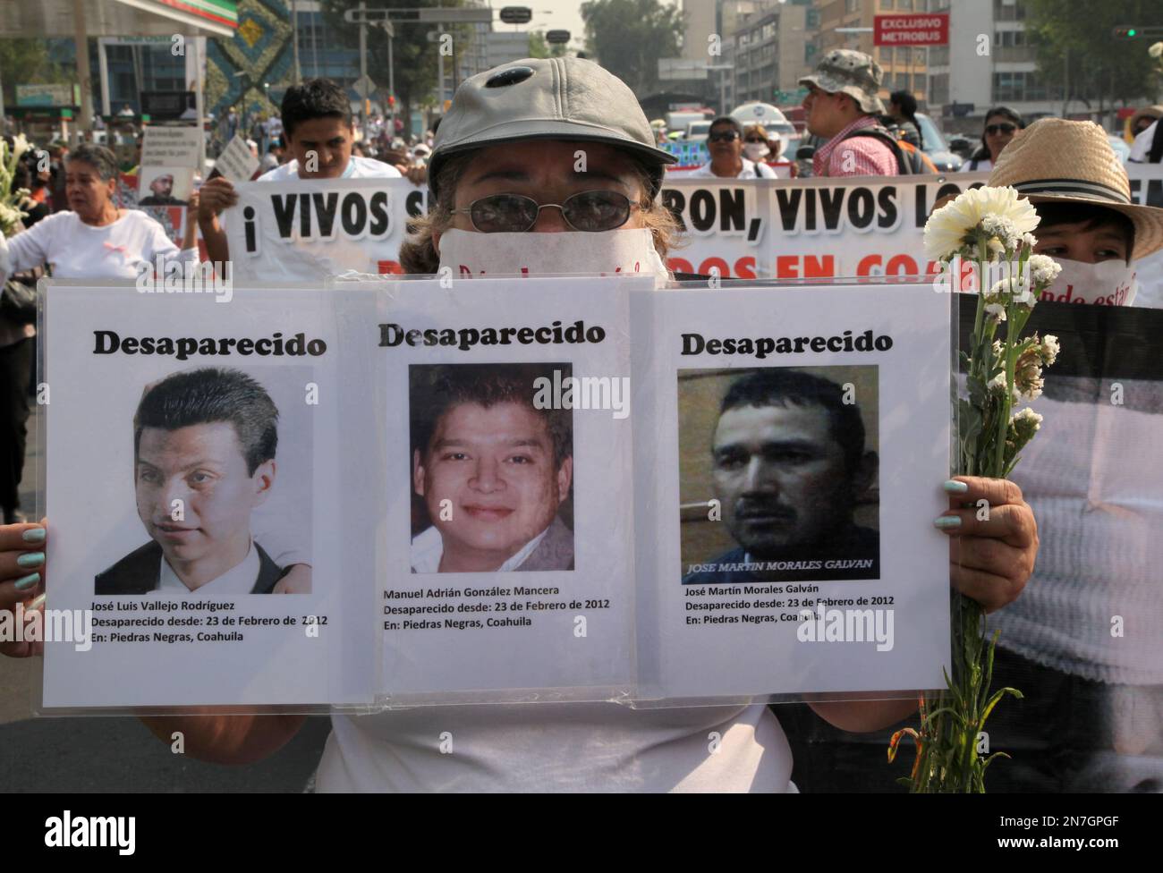 A woman holds photo copies of men disappeared during the National March