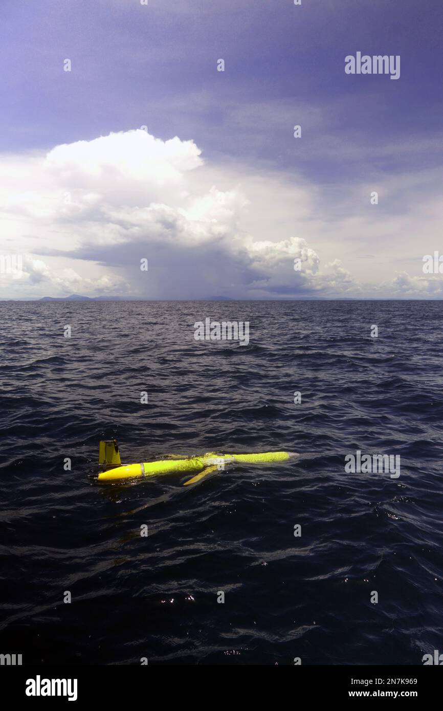 Slocum ocean glider (yellow) on the waters of the Great Barrier Reef, with wet season storm in background, Queensland, Australia. No PR Stock Photo