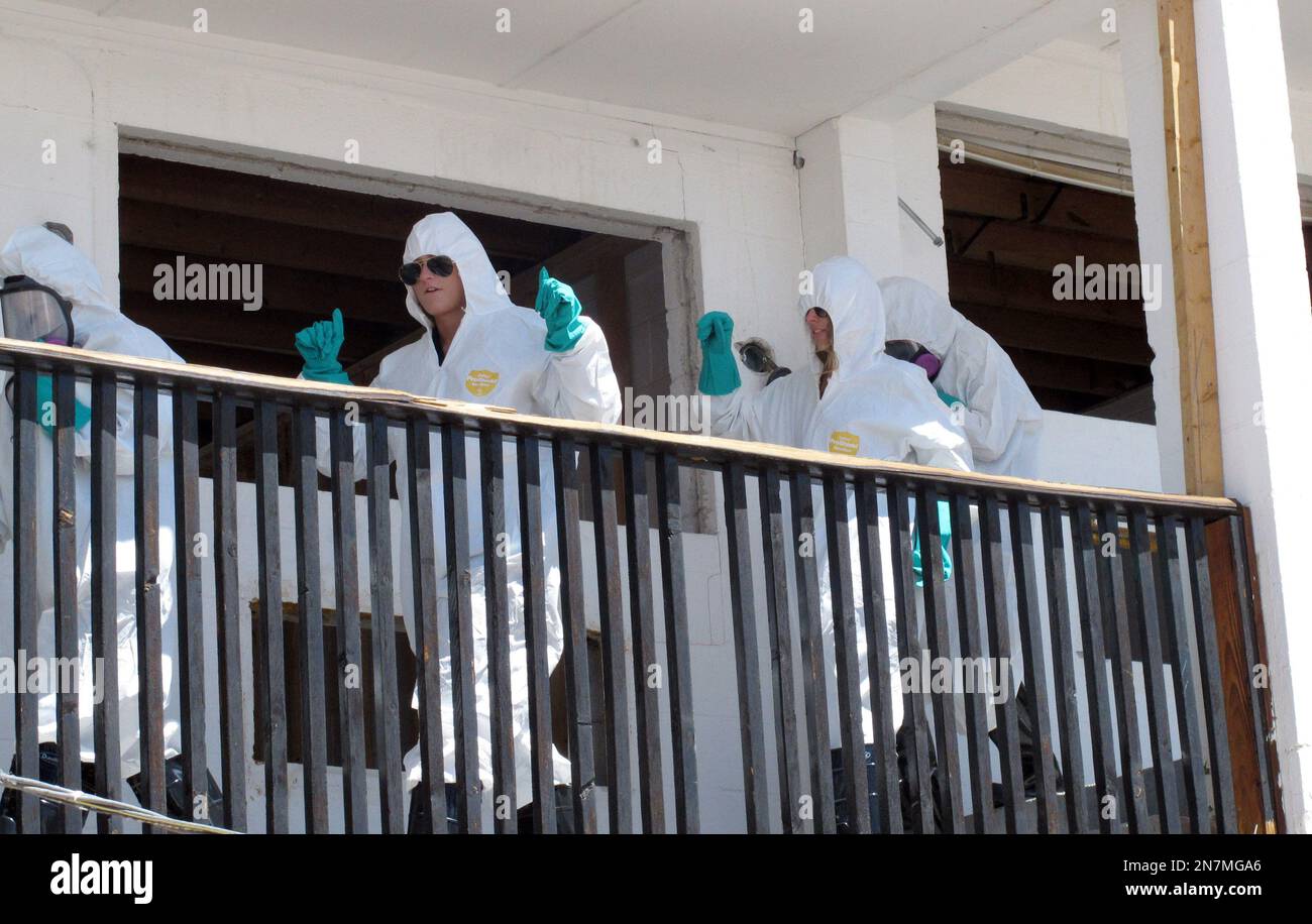 Asbestos removal workers dance at the groundbreaking ceremony Thursday
