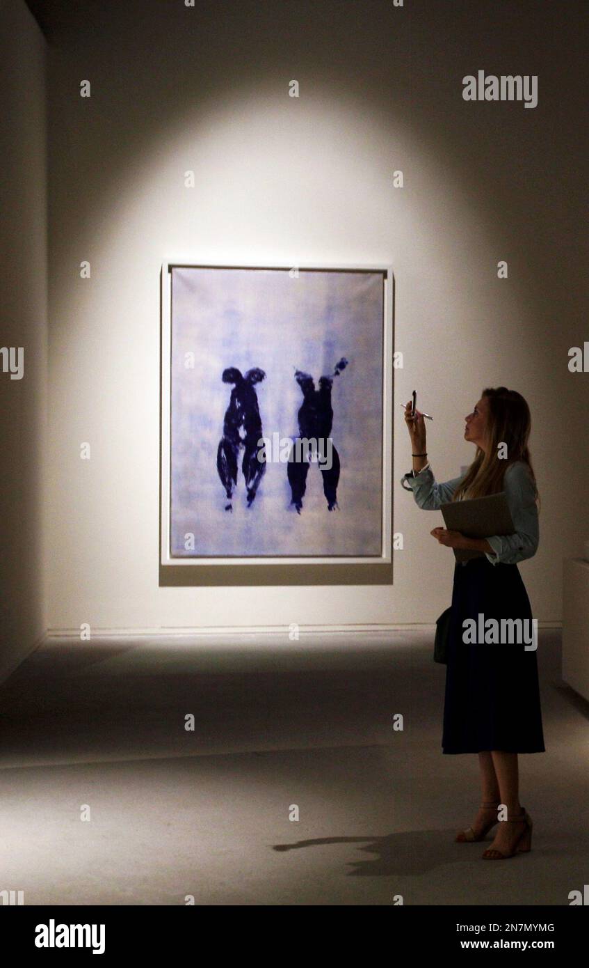 A journalist takes a photo in front of "Anthropometry" by French artist  Yves Klein which is part of a sample collection at the Abu Dhabi branch of  the Louvre in Abu Dhabi,