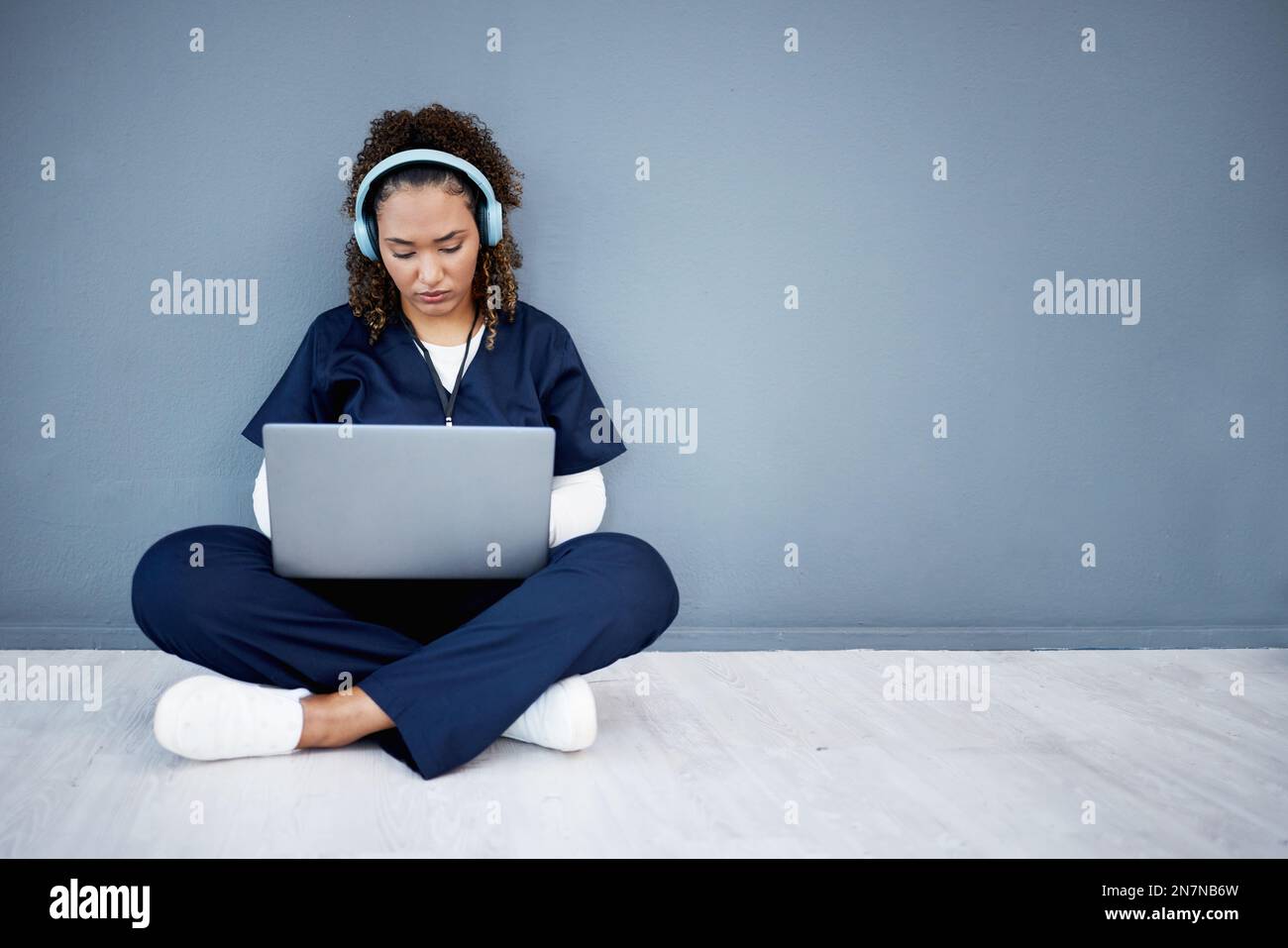 Woman, laptop and headphones of hospital music, podcast or radio in woman study research or mockup nurse learning. Doctor, technology and medical Stock Photo