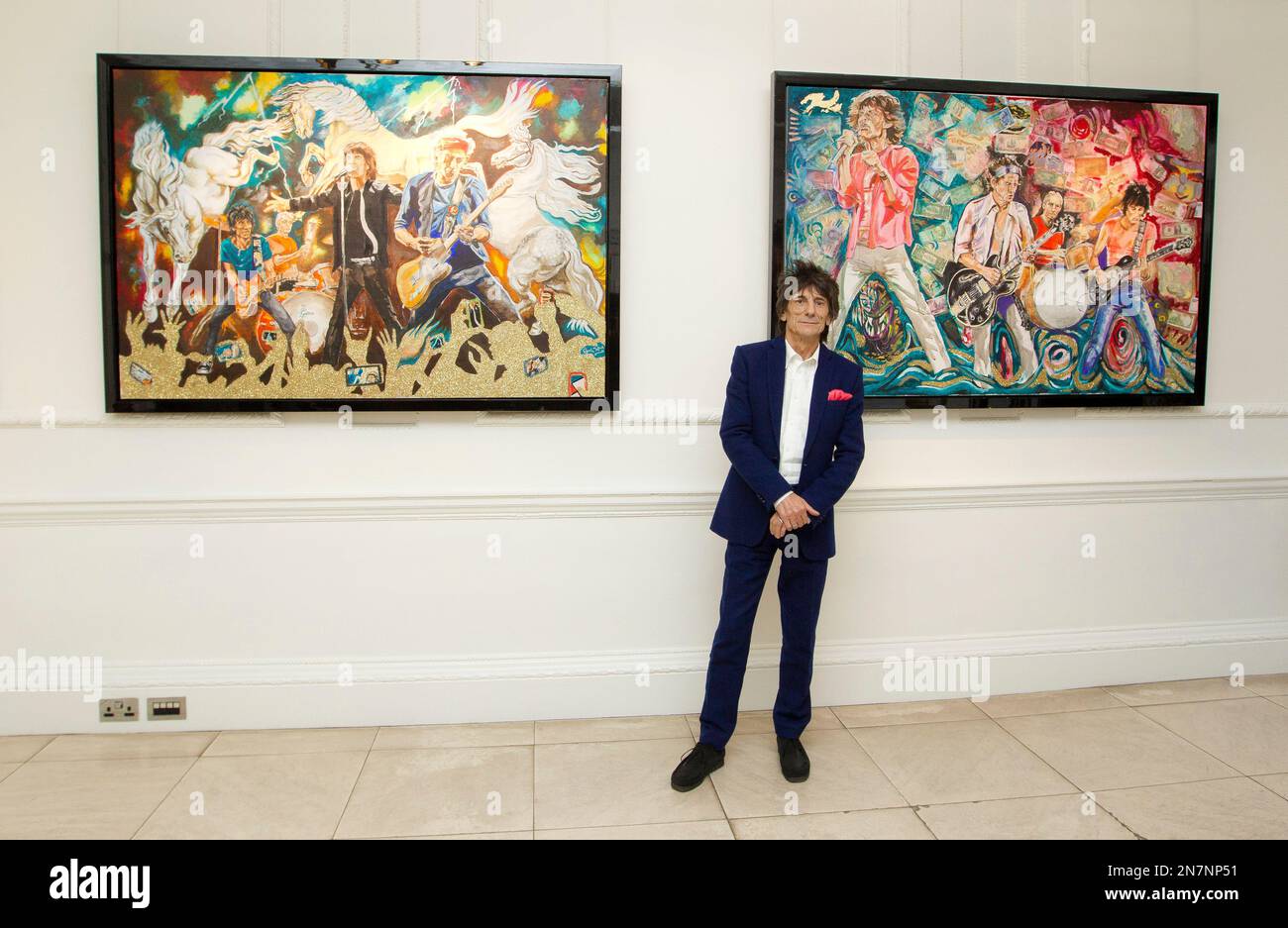 Ronnie Wood poses for a photograph in front of his paintings titled, "What Price Tickets