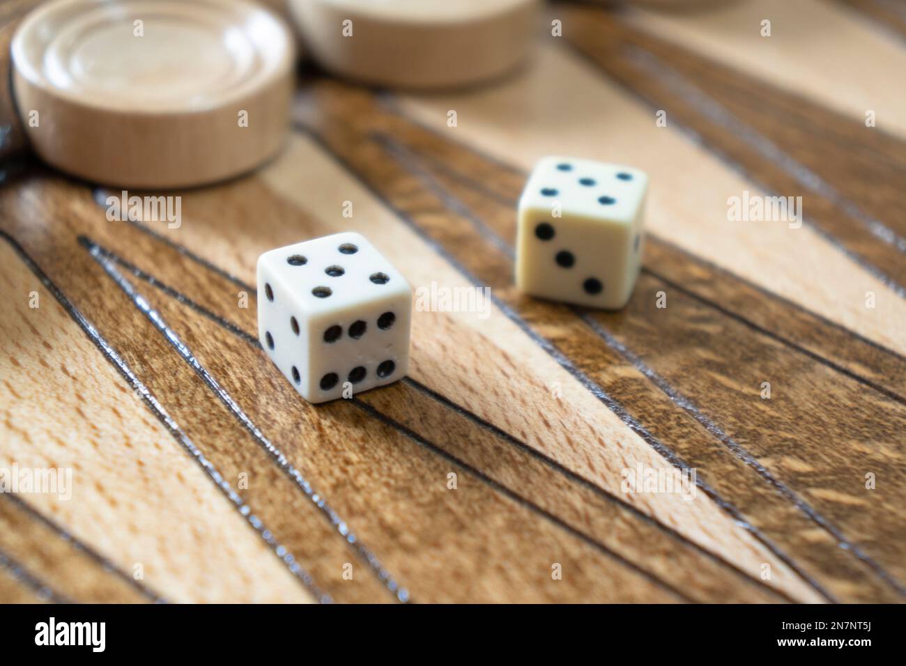 Closeup of backgammon board game. Wooden backgammon board with checkers and dice pair Stock Photo