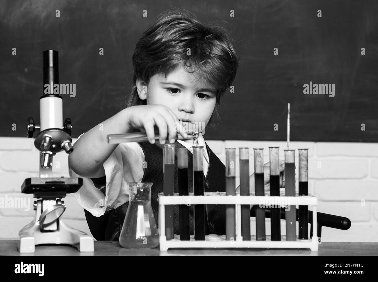 Education. Happy smiling pupil drawing at the desk. Chemistry. The ...