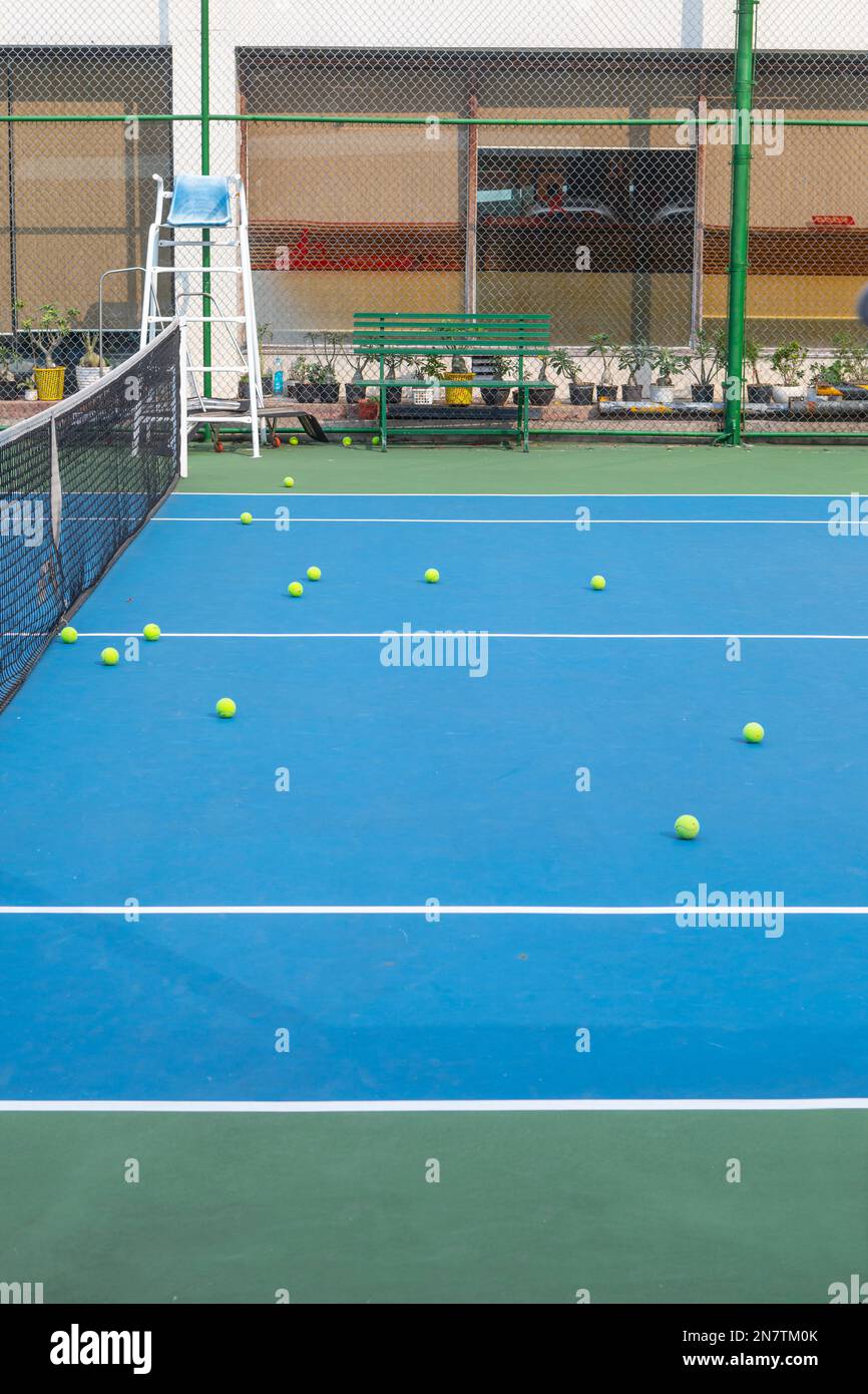 Tennis balls on a tennis court after a practice session in District 2, Ho Chi Minh City, Vietnam. Stock Photo