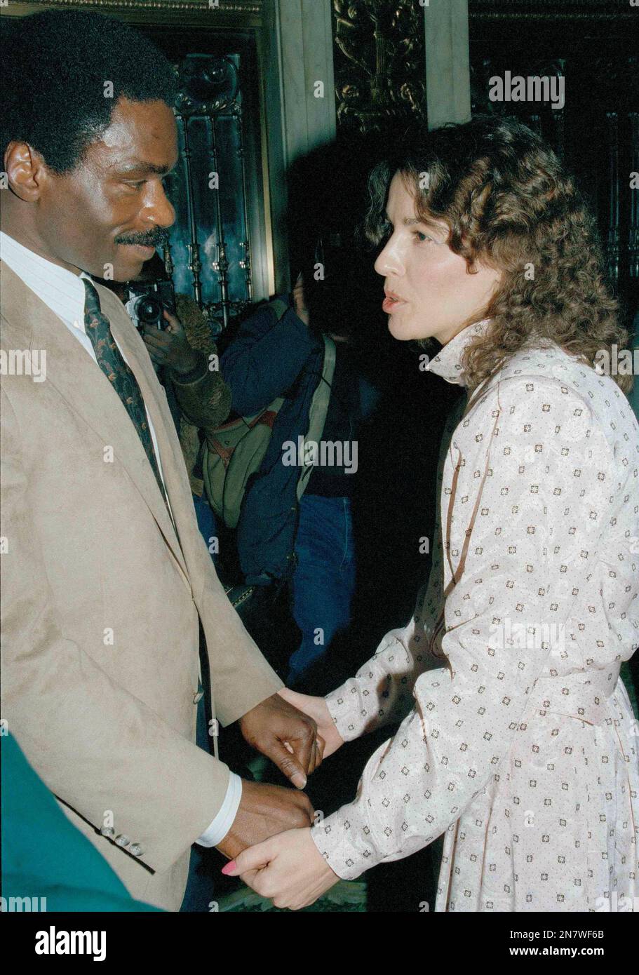 Rubin "Hurricane" Carter, left, holds the hands of Dolly Artis, wife of  John Artis, during a New York City press conference, Feb. 29, 1988. Carter  said he holds no bitterness for serving