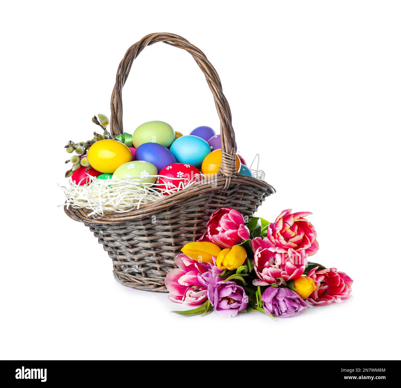 Wicker basket with bright painted Easter eggs and spring flowers on ...