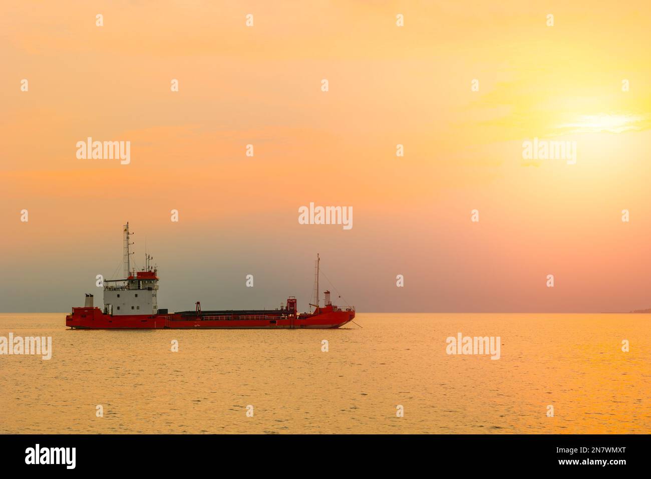Transport cargo boat ship with sunset sea ocean shipping for import export industry scene view Stock Photo