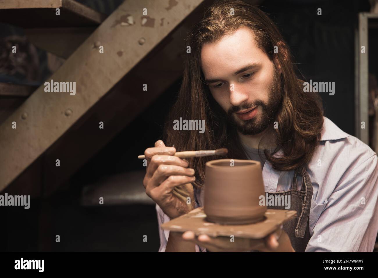 pottery man master work painting clay cup. handcraft pot artist maker with care. Stock Photo