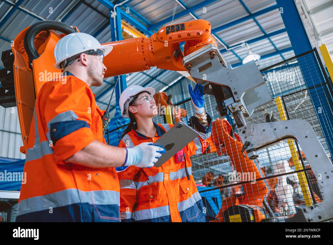 engineer teamwork working in automation factory service program robotic arm welding assembly Stock Photo