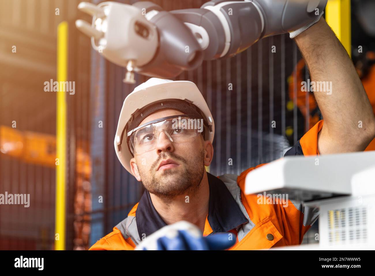 Automation Engineer Service checking Robotic Arm. New Era Modern Machine Automatic Manufacturing Industry Concept. Stock Photo