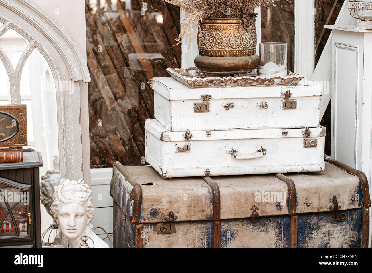 Pile of vintage ancient suitcases trunks in form of tower with old vase ...