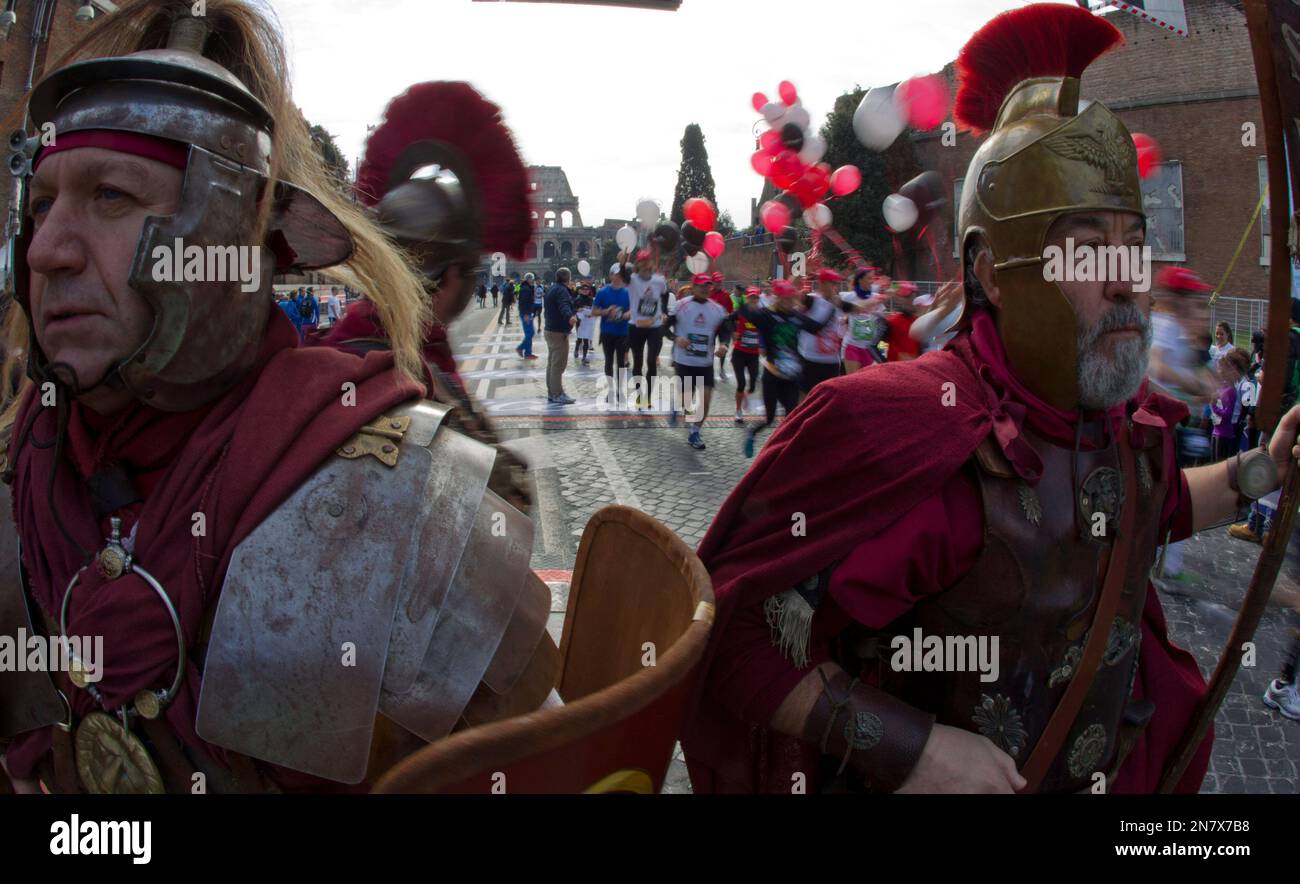 Ancient Rome Running Athletes run past two men dressed as ancient Roman centurions in front ...