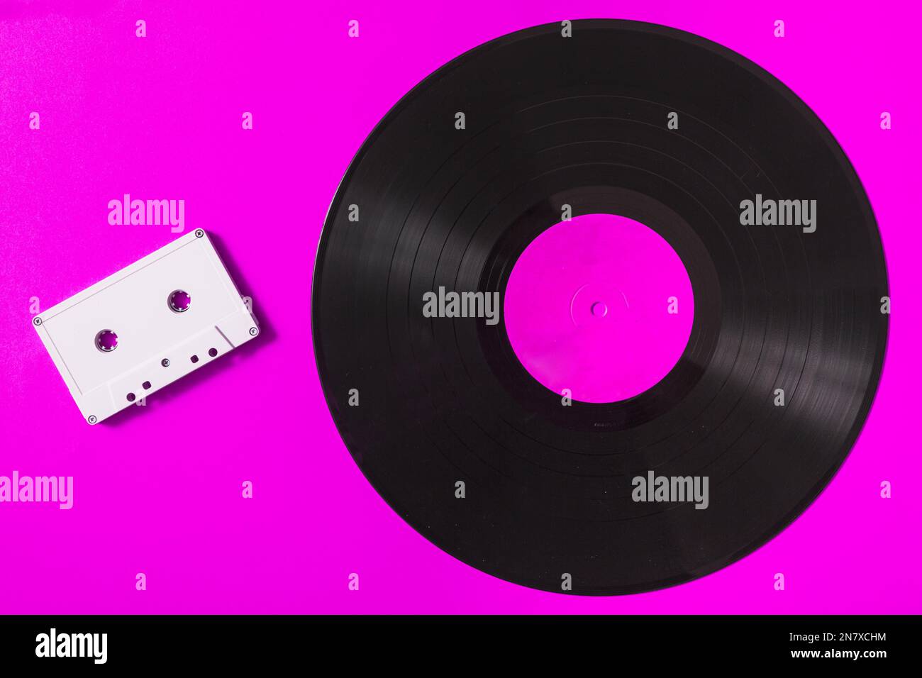 audio white cassette tape vinyl record pink background Stock Photo