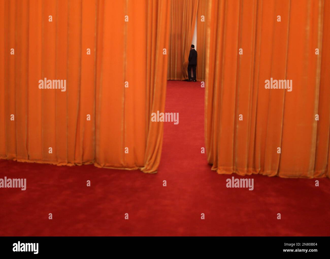 A Chinese soldier dressed as an usher stands guard at a corridor of the Great Hall of the People, where National People's Congress delegates are holding group discussions, in Beijing, China, Thursday, March 7, 2013. (AP Photo/Kin Cheung) Stock Photo