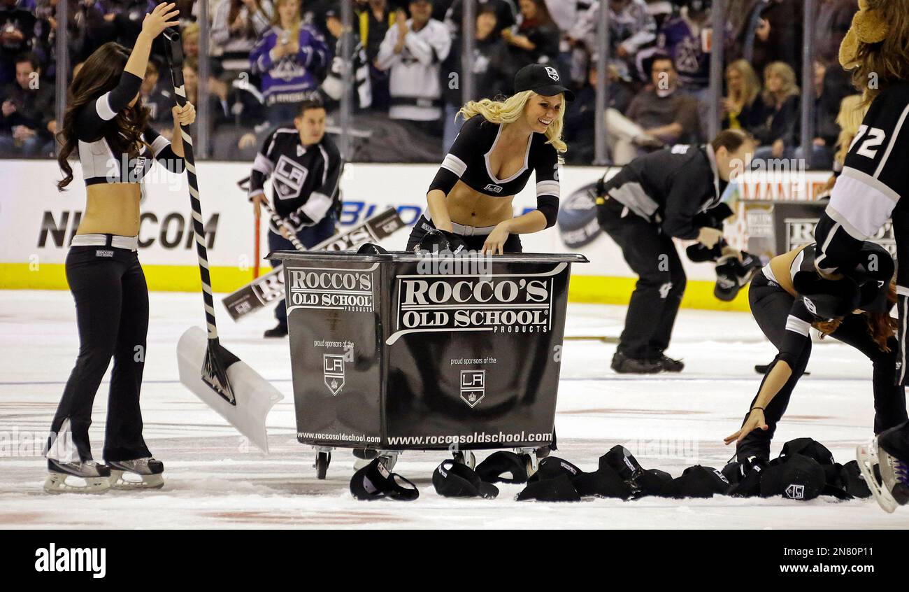 Members of the Staples Center ice crew pick up hundreds of hats tossed