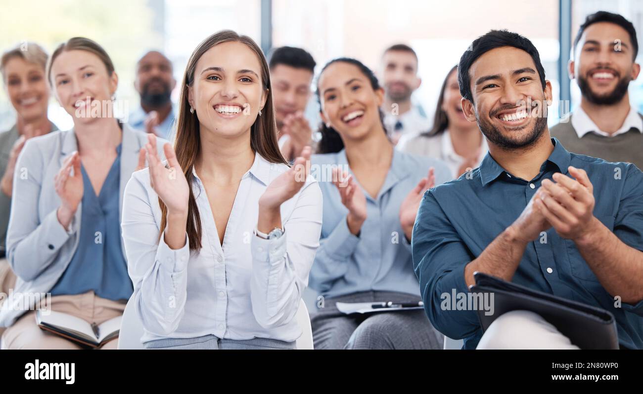 Diverse group of smiling businesspeople clapping in office training ...