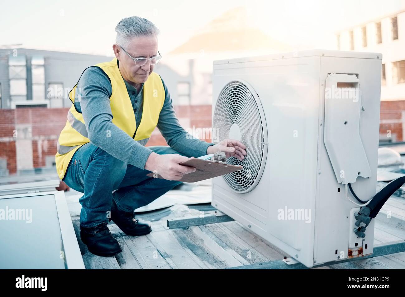 Engineer on rooftop, air conditioning and technician with clipboard
