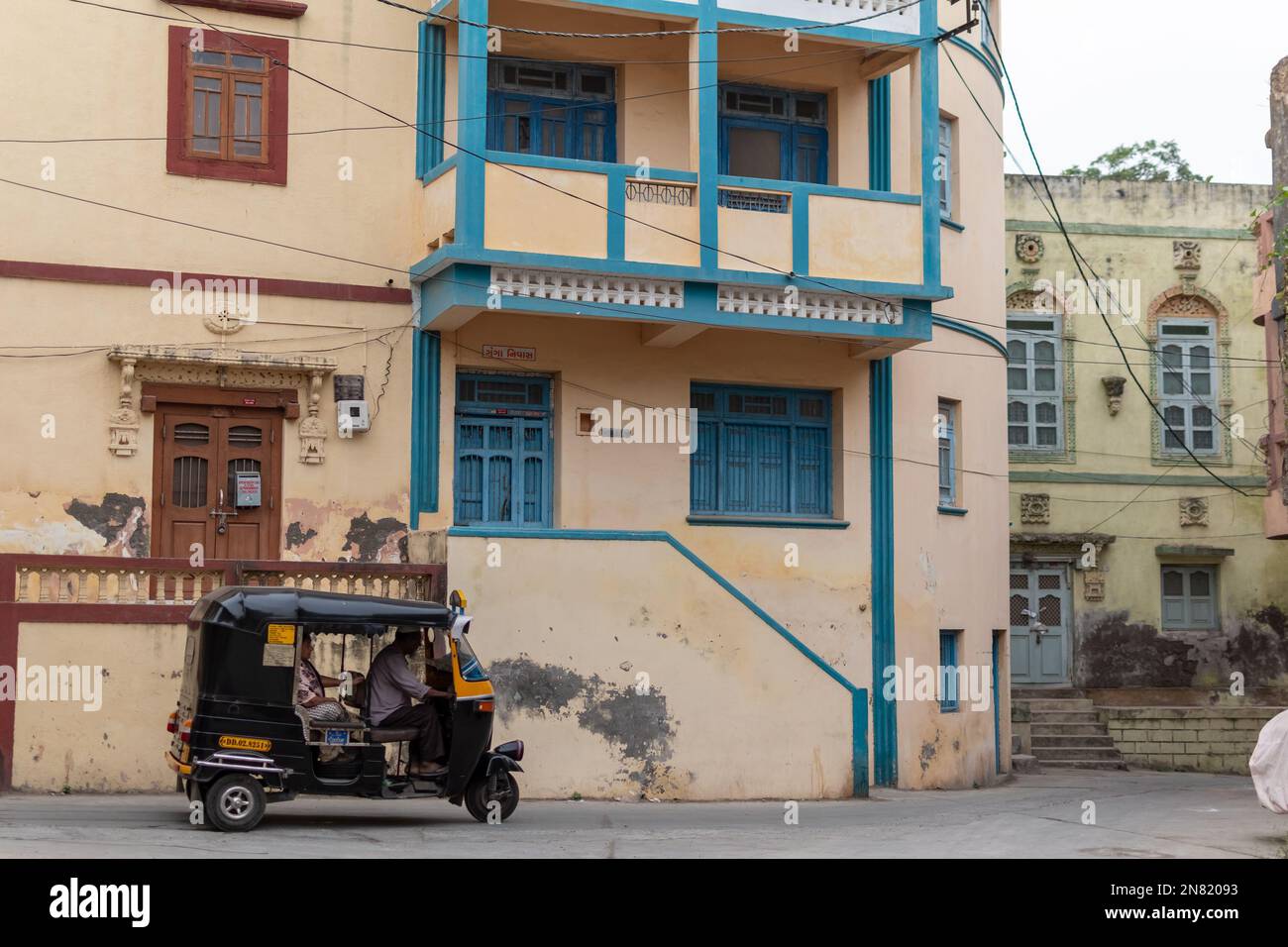Diu, India - December 2018: An autorickshaw going past an old house with vintage balconies in the old town of Diu. Stock Photo