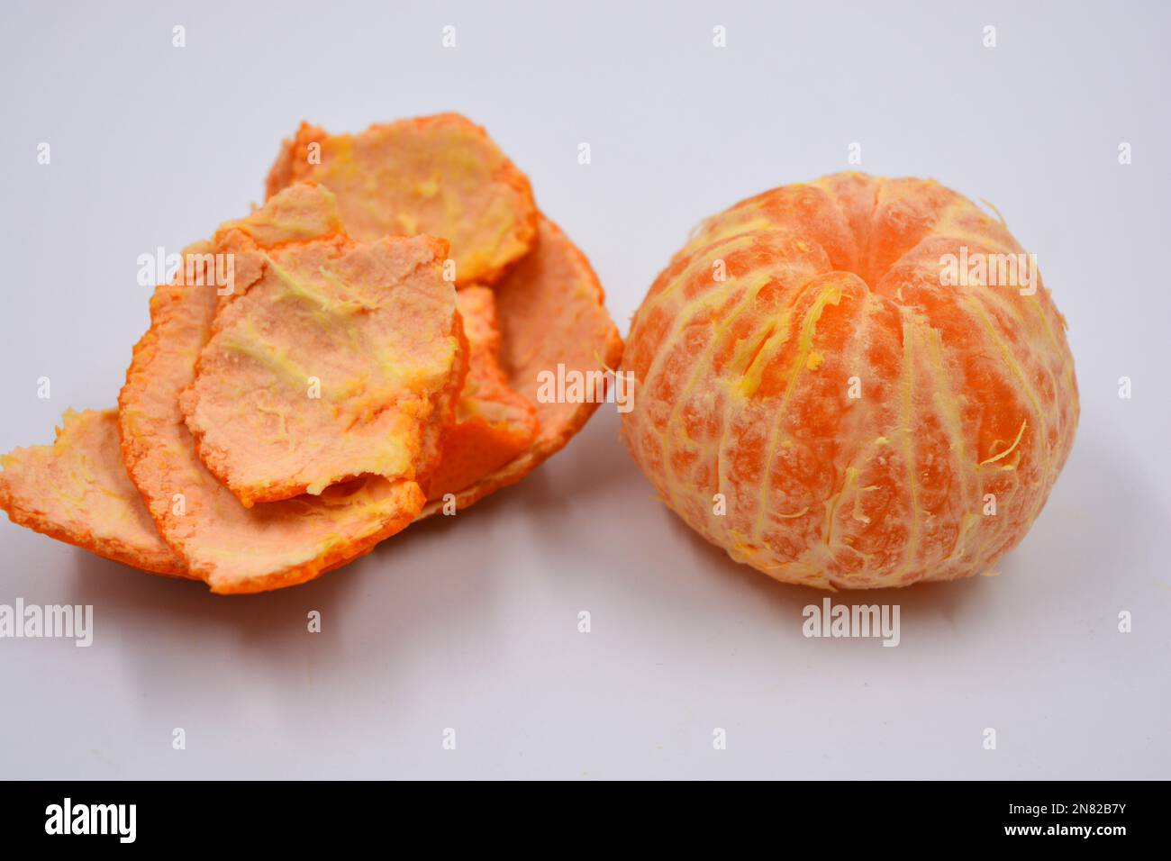 Ripe peeled orange tangerine, sweet fruit with orange skin located on a white background in different positions. Stock Photo