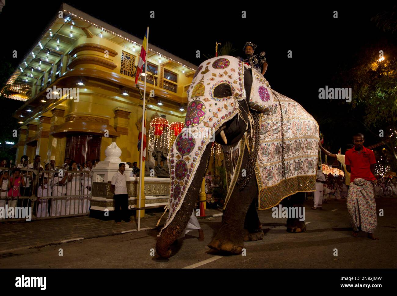 A Sri Lankan man dressed in traditional clothes rides on a 