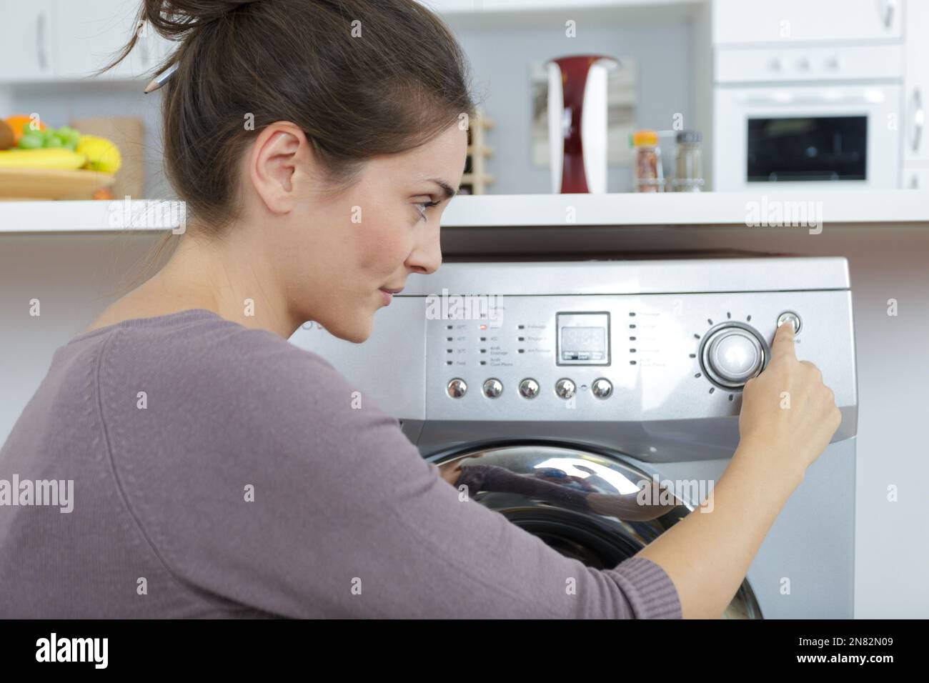 woman loading dirty clothes in washing machine Stock Photo Alamy