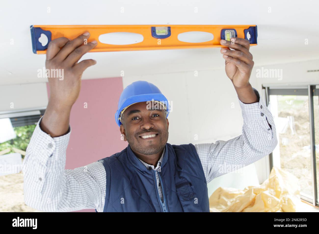 laborer holding a level on the ceiling Stock Photo