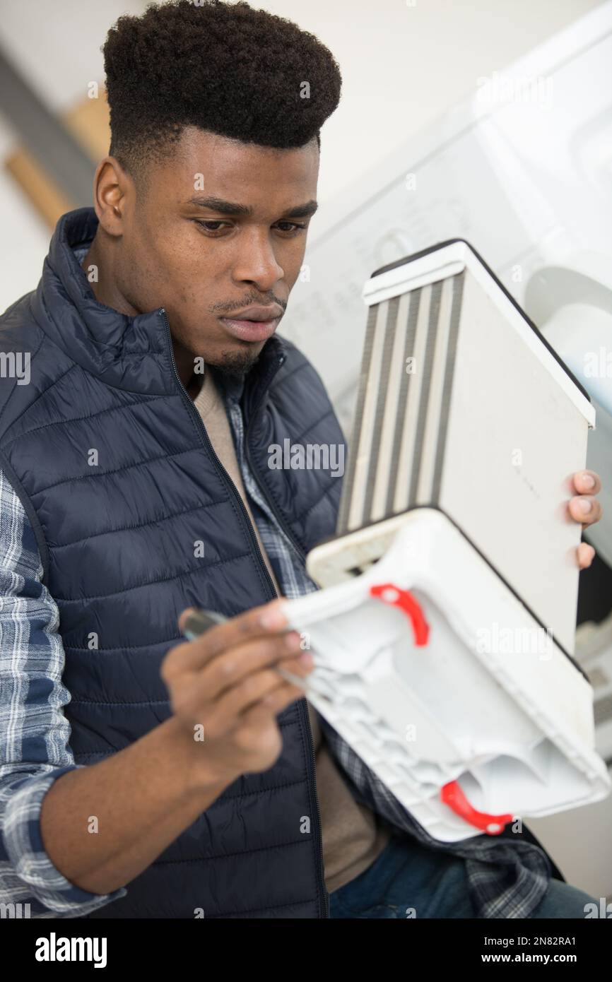 engineer holding tumble drier condenser Stock Photo Alamy