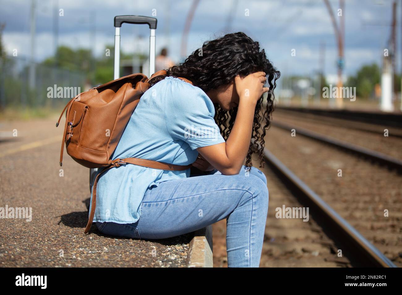 sad woman with depression sitting on railway track Stock Photo Alamy