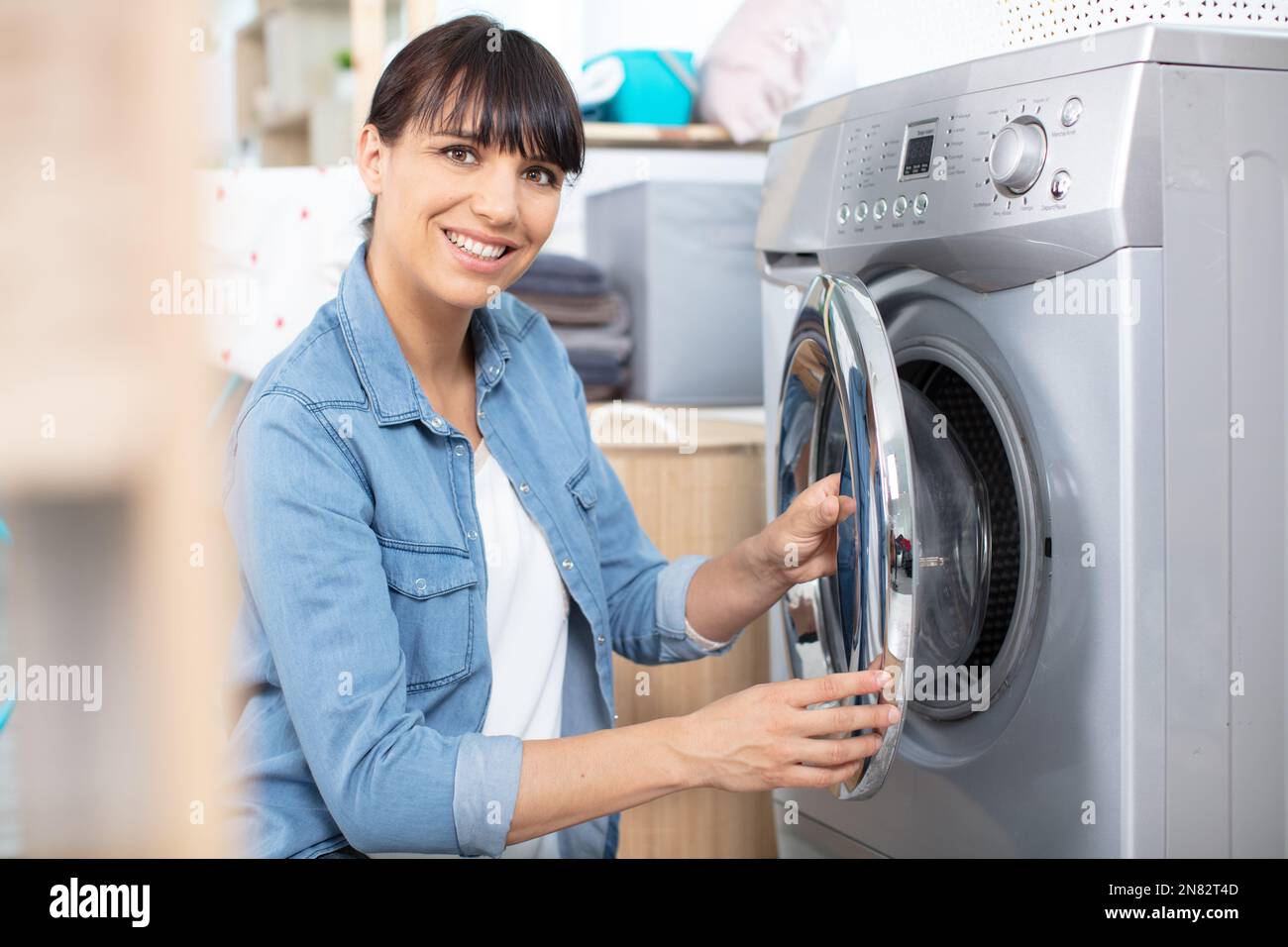 woman doing homework filling washing machine Stock Photo Alamy