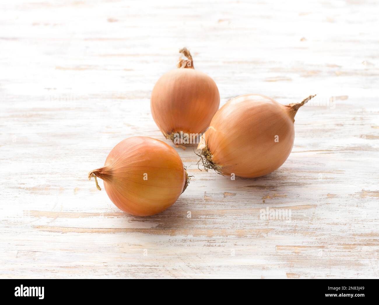 Onions on a light wooden background, selective focus, horizontal Stock Photo