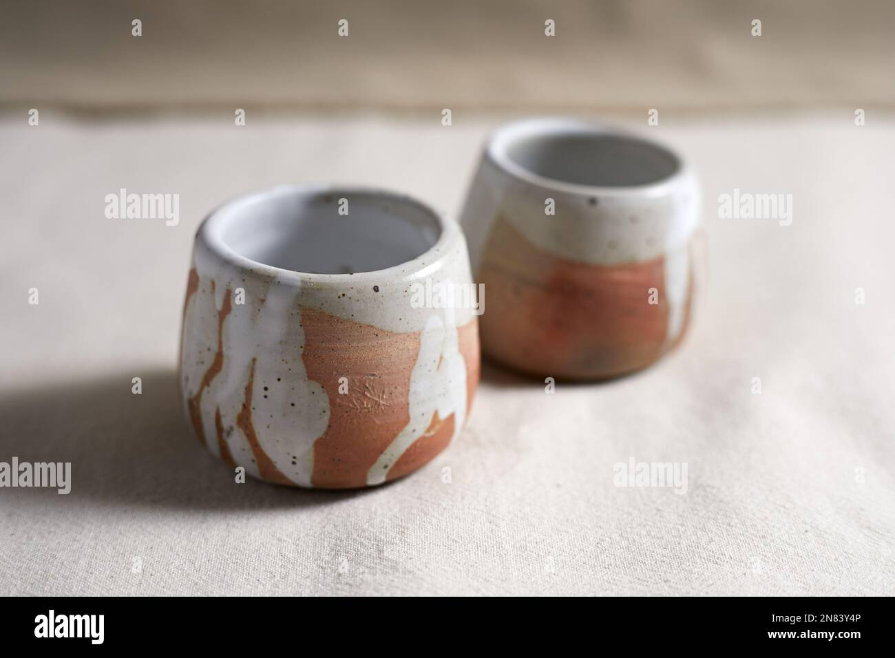 Handmade empty craft ceramic on  textile background. Stock Photo