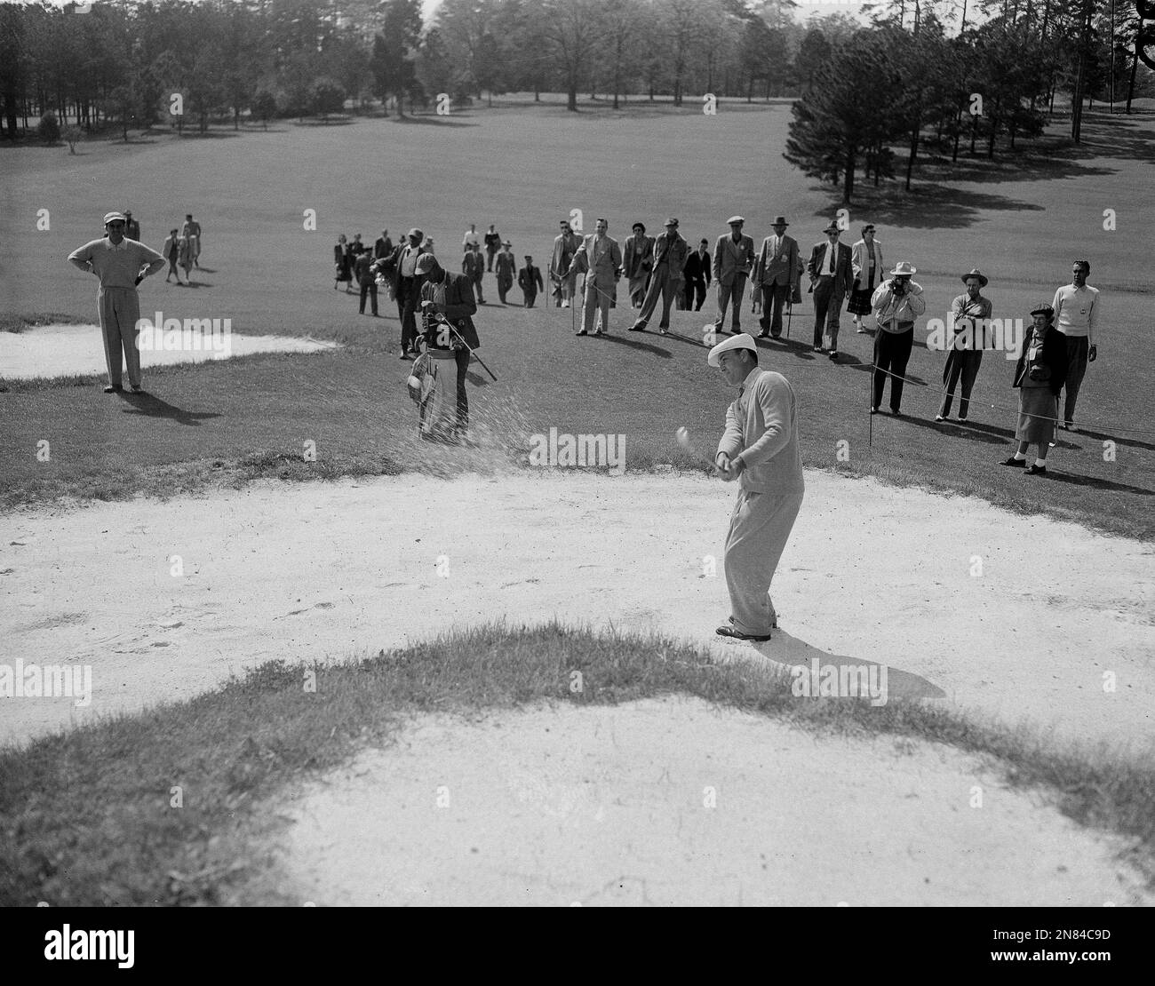 Pro golfer Ben Hogan blasts from a sand trap approaching the 9th green ...