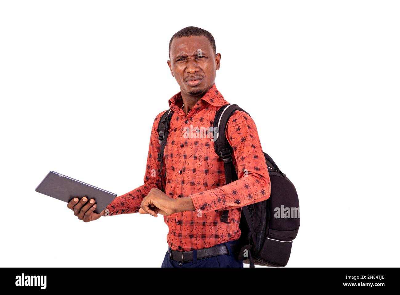 young disgruntled student man with backpack holding digital tablet Stock Photo